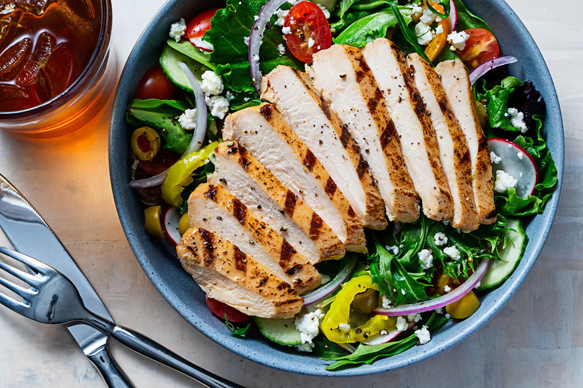 Grilled Sliced Chicken Breast sliced over a bowl of salad